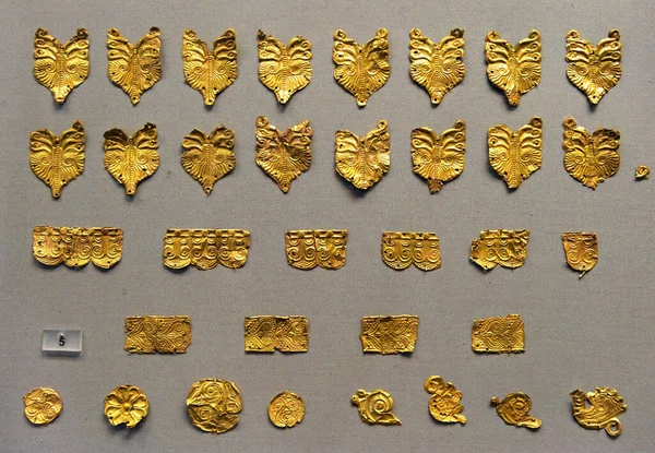 Athens - May 7, 2018: Jewelry from ancient Greek Mycenae (Mykines) in National Archaeological Museum, Athens, Greece. Gold jewels attached to clothing. Theme of history, artifact, wealth, archeology