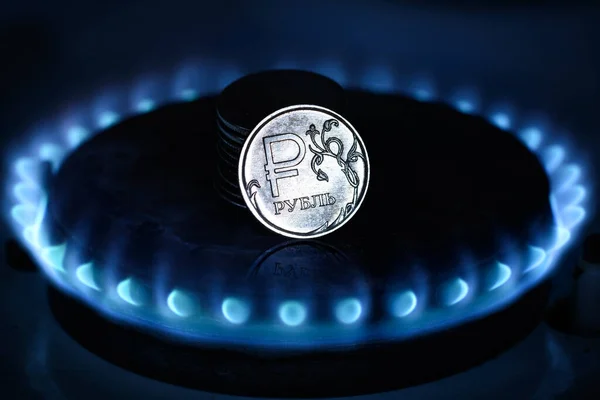 Gas burner and ruble coin, Russian money on home gas stove. Blue propane gas flame and ruble currency. Concept of Russia and Europe economy, natural gas cost, inflation, sanctions and payment.
