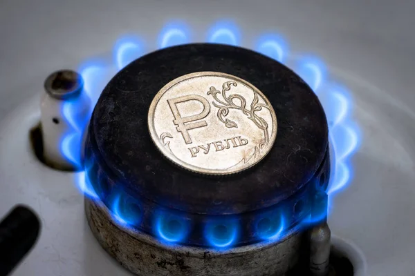 Gas burner and ruble coin, Russian money on home gas stove. Natural propane gas flame and ruble currency. Concept of Russia and Europe economy, gas cost, inflation, EU sanctions, crisis and trade.