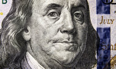 Macro view of 100 US dollar bill, Benjamin Franklin portrait on one hundred USA dollar note close up. USD paper money with president eyes, face on dollar banknote closeup. American currency concept.