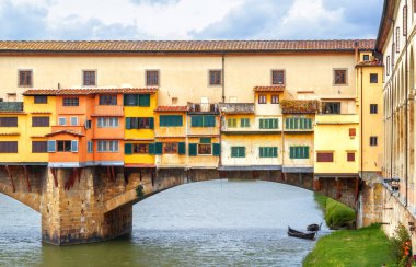 Ponte Vecchio over Arno river, Florence, Italy. This old bridge with jewelry and art shops is famous tourist attraction of Florence. Concept of Tuscany, travel, Renaissance architecture and water. 