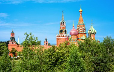Moscow Kremlin and St Basil's Cathedral in summer, Russia. Scenic nice view of famous Moscow city landmarks and blue sky from green park. Travel, nature, landscaping and tourism in Russia concept.