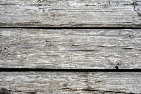 Wood barn planks background, old rustic wooden wall close-up. Weathered rough timber with cracks, grain and knots, gray vintage dry boards for wallpaper. Wood texture, woodgrain and nature theme.