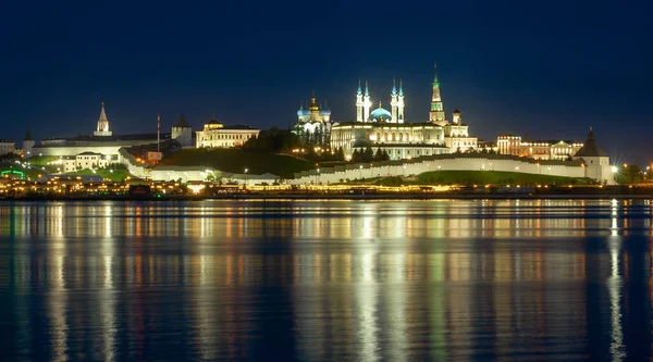 Kazan Kremlin by river at night, Tatarstan, Russia. It is top sight of Kazan. Panorama of white fortress and its landmarks. View of old Kazan city and reflections in water. UNESCO World Heritage site