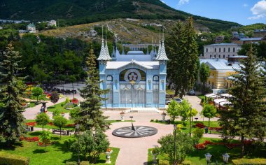 Park Flower Garden in Pyatigorsk, Stavropol Krai, Russia. Scenic view of Lermontov Gallery, historical landmark of Pyatigorsk installed in 1901. Mashuk Mount in background. Landscape and travel theme