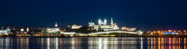 Kazan Kremlin by river at night, Tatarstan, Russia. Panorama of old white fortress, main landmark of Kazan. View of Kazan city center and reflections in water. UNESCO World Heritage site