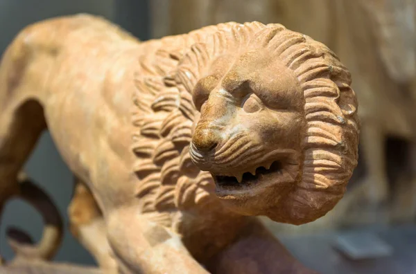 Stone statue of lion, ancient Greek sculpture of animal, marble ferocious lion close-up. Theme of culture, antique, art, civilization.
