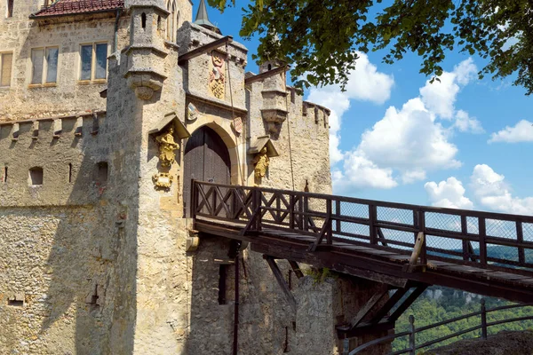 リヒテンシュタイン城の門は ドイツ ヨーロッパの夏に古い木製の橋を持っています この有名な城はシュワルツァルトのランドマークです バーデン ウルテンベルクの青空に対するゴシック様式の城の入り口 ロイヤリティフリーのストック写真