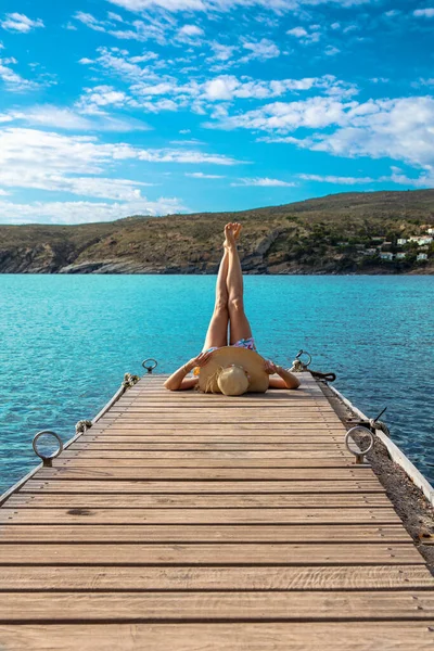 ターコイズブルーの海の前の木製の桟橋に女性の足 リラックス 休暇のコンセプト — ストック写真