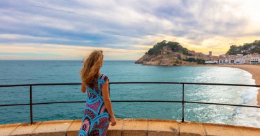 Tossa de Mar 'ın panoramik manzarasından hoşlanan kadın turist Costa Brava' daki güzel plaj - İspanya