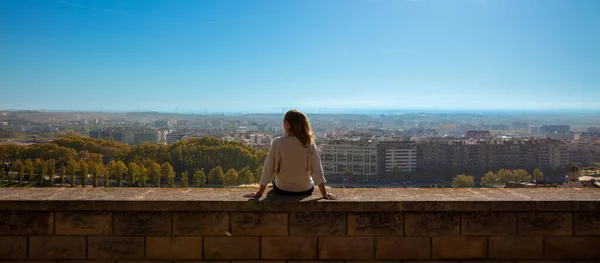 Женщина Сидящая Стене Смотрящая Городской Пейзаж — стоковое фото