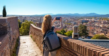 Girona 'da fotoğraf çeken kadın turist, şehrin panoramik manzarası... İspanya