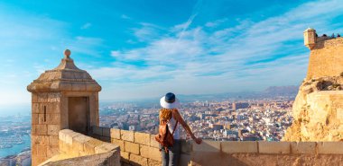 woman tourist looking at panoramic view of Alicante city,  Spain clipart