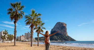 Woman looking at Calpe rock and mediterranean sea in Spain clipart