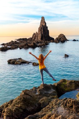 İspanya, Cabo de Gata 'daki kayalık oluşuma bakan mutlu bir kadın.