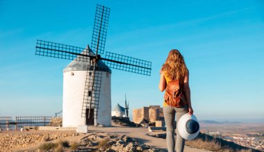 Woman tourist looking at windmills ,Consuegra near Toledo, Castile-La Mancha, Spain