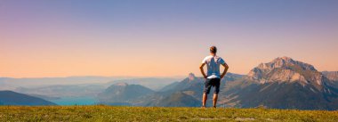 Man looking at panoramic view of sunset mountain