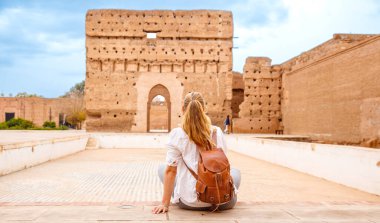 Woman tourist visiting old ruin palace ( Palais El Badi) in Marrakech,  Morocco clipart