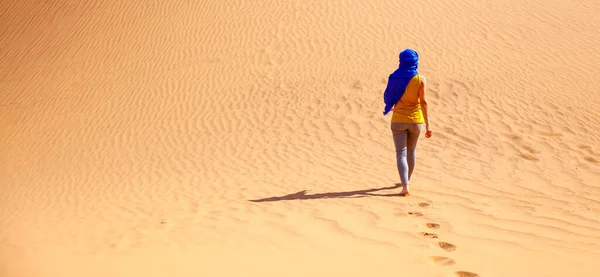 青いターバンでサハラ砂漠を歩く女性観光客 — ストック写真