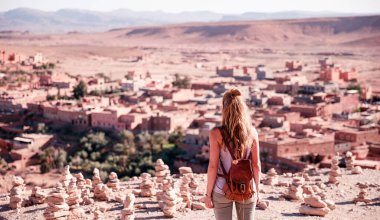 Ait Ben Haddou şehrinin panoramik manzarasına bakan kadın turist. Fas manzarası.