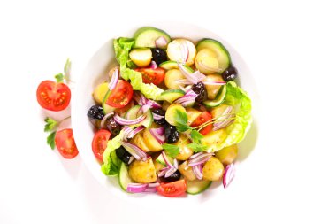 Patates, domates, zeytin ve soğanlı karışık sebze salatası.