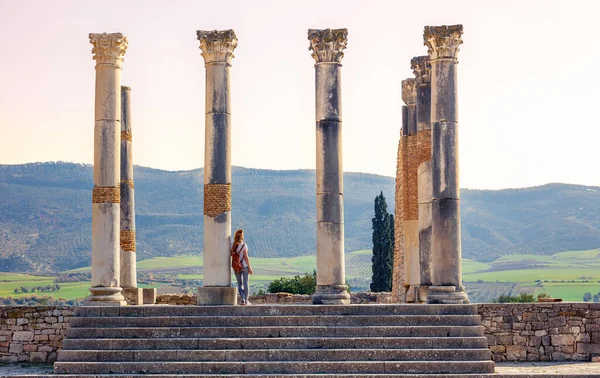 モロッコの有名なローマ遺跡 Volubilis 美しい列と廃墟を楽しむ女性観光客 — ストック写真