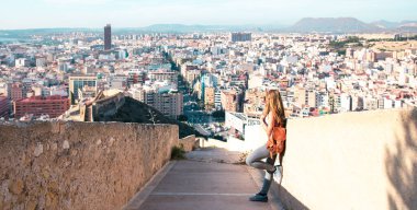 Alicante şehir manzarası ve panoramik manzaraya bakan kadın turist