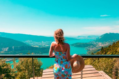 Fransa 'daki Annecy Gölü' nün panoramik manzarasına bakan kadın.