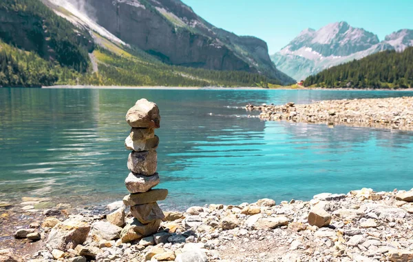 Zen dengeleyici çakıl taşları turkuaz göl ve dağların yanında - İsviçre