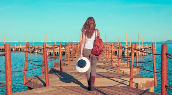 海を眺めながら木の桟橋を歩く女 — ストック写真