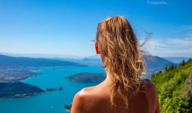 Fransa 'daki Annecy Gölü' nün panoramik manzarasına bakan kadın.