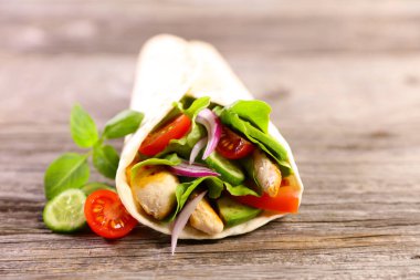 Kızarmış tavuk ve sebzeli Meksika usulü tortilla.