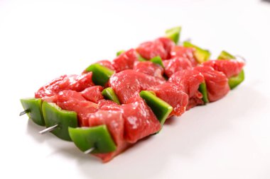 Beyaz arkaplanda çiğ et şişi izole edilmiş.