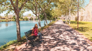 Merida 'da bir bankta oturan kadın turist. Estremadura.