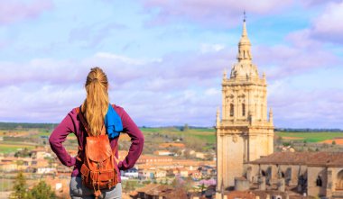 İspanya 'da Burgo de Osma-Kastilya katedraline bakan kadın turist ve Leon