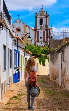 Portekiz 'de turizm, Silves caddesinde yürüyen ve katedrale bakan bir kadın, Algarve' de seyahat.
