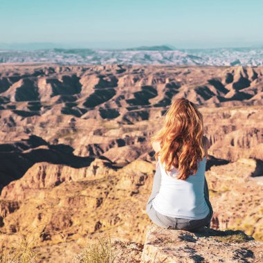 Woman sitting and looking at sunset Gorafe desert in Spain