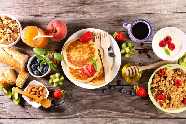 Healthy breakfast with pancakes,  muesli , fruit juice and coffee cup