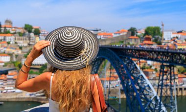 Güzel panoramik manzaranın tadını çıkaran kadın turist ünlü demir köprü Portekiz 'de turizm, Porto' da seyahat