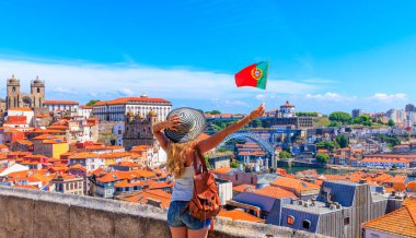 Porto, Portekiz 'in panoramik manzarası önünde Portekiz bayrağını tutan bir kadın turist.