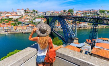 Douro Nehri 'nin güzel panoramik manzarasından hoşlanan kadın turist, eski kasaba ve ünlü demir köprü Portekiz turizmi, Porto' ya seyahat.