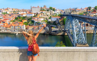 Porto şehri ve köprü manzarasının tadını çıkaran kadın turist Portekiz