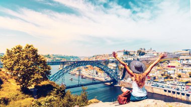 Nehir ve ünlü demir köprüsü Porto şehri Portekiz 'in güzel panoramik manzarasının tadını çıkaran kadın turist.