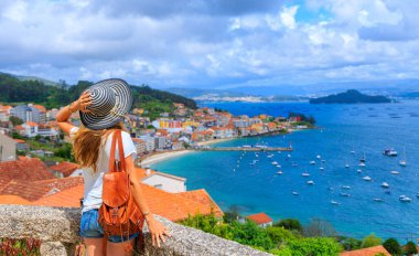 Kadın turist Raxo köyünün panoramik manzarasını seyrediyor, Pontevedra - İspanya