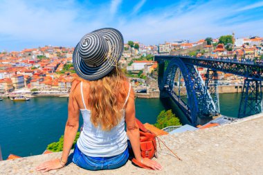 Portekiz 'de seyahat eden şapkalı ve çantalı bir kadın. Porto şehri, yaz tatili.