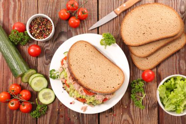 Ton balığı, avokado ve sebzelerle dilimlenmiş ekmek.