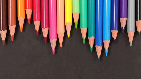 banner of group of colored pencils on desk- top view