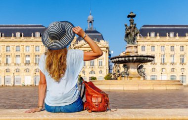 Bordeaux şehrindeki Bourse Meydanı 'na bakan kadın turist. Fransa' da turizm.