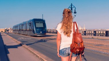 Bordeaux şehrinde, köprüde tramvayı olan bir kadın.