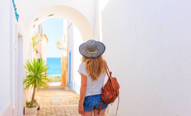 Portekiz 'de sokakta yürüyen kadın turist. Algarve' de turizm.